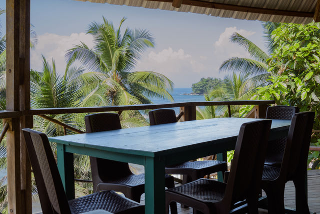 Rondreis Colombia Choco Nuqui El Cantil Ecolodge Tafel met tropisch behang op de achtergrond (maar dan echt)